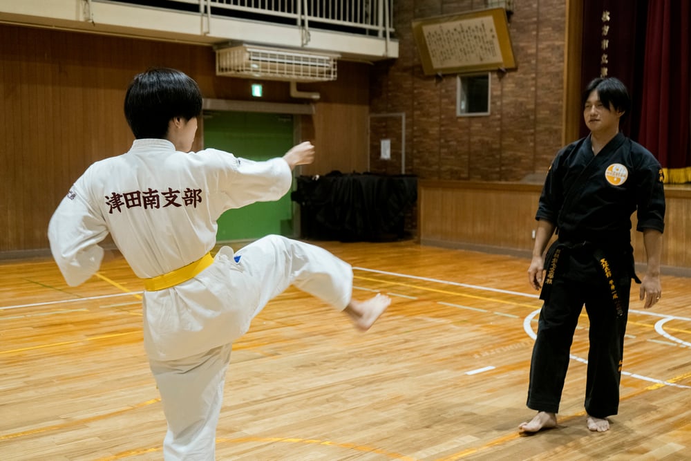 師範との組手稽古で高い蹴りを見せる道場生